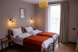 a bedroom with two beds and a large window at Baza Kazbegi in Kazbegi