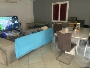 a living room with a couch and a tv at Maison partager in Port-de-Lanne