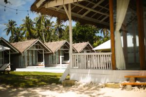 a row of houses with a porch and palm trees at La Belle Hollow Trees in Katiet