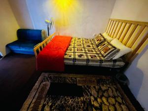 a small bedroom with a bed and a chair at Walauwa Bungalow in Katugastota +9 photos