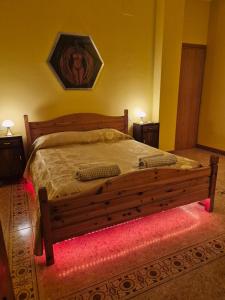 a bedroom with a wooden bed with a red rug at Manuel suites in Pianella