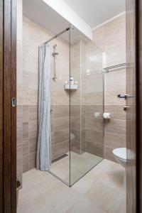 a bathroom with a glass shower with a toilet at Kollar D Guest House - Prenoćište ROOMS in Subotica