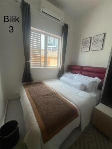 a bedroom with a large bed with a window at Kj Resident Homestay in Alor Setar