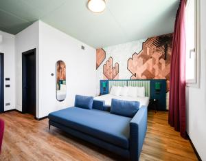 摩德纳CX Modena Crocetta的卧室在床前配有蓝色沙发