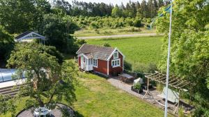 a small red and white house in a field at Röhällastugan in Färjestaden