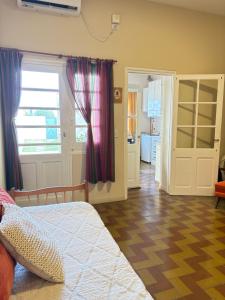 a bedroom with a bed and a room with a kitchen at Casa verde in Cañada Rosquín