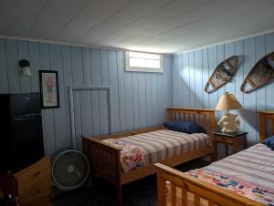 a bedroom with two beds and a tv in it at Logged Inn in Caroga Lake