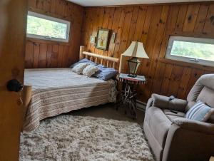 a bedroom with a bed and a couch at Logged Inn in Caroga Lake