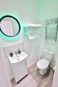 a bathroom with a white toilet and a mirror at 2 Bedroom Apartment Southsea - Sleeps 5 & Free Parking in Portsmouth