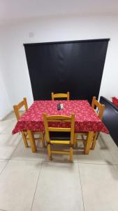 a table with two chairs and a red table cloth at Juanita in Toay +7 photos