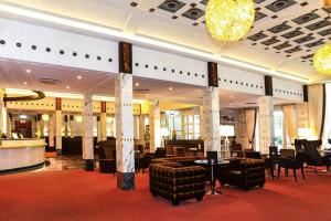 een lobby met stoelen en tafels en een bar bij Steigenberger Hotel & Spa Bad Pyrmont in Bad Pyrmont