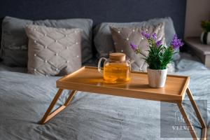 a wooden tray with a jar of honey and flowers on a bed at Stylish Chalet 5min to Beach in Swansea