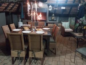 Un comedor con una mesa con sillas y una lámpara de araña. en The Lion Room at Frederick's Place, en Pretoria