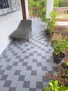 a patio with a bench on a checkered floor at Diamond Coast Apartment Paje in Paje +8 photos