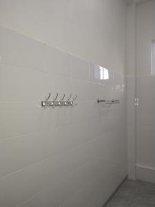 a bathroom with white walls and a shower at Diamond Coast Apartment Paje in Paje
