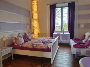 a bedroom with a bed and a window at Kunstgut Patapaya in Neukalen