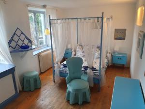 a bedroom with a bed and a chair and a table at Kunstgut Patapaya in Neukalen +17 photos