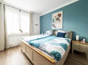 a bedroom with a bed with blue walls and a window at Ferienwohnung-Ohetal in Breddenberg +3 photos