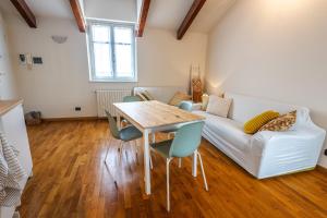 a living room with a table and a couch at Casa Musotta - Dimora nelle Langhe in Alba