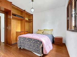 a bedroom with a bed and a book shelf at Refúgio Natureza Piscina Sala de Jogos Lazer in Campo Limpo Paulista