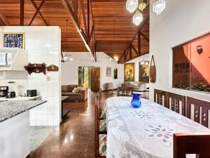 a kitchen and living room with a table with a vase on it at Refúgio Natureza Piscina Sala de Jogos Lazer in Campo Limpo Paulista