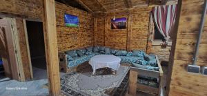 a living room with a blue couch and a table at Lovely wooden chalet for families -Dar louh- in Kenitra +8 photos