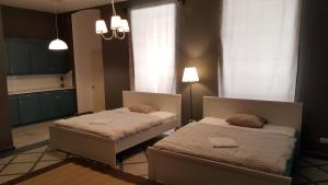 two beds in a room with a kitchen at Cozy Central Retreat in Budapest +10 photos