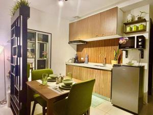 a kitchen with a wooden table and green chairs at Sarinas Place Sitari in Bacolod