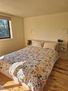a bedroom with a bed with a colorful comforter at Casa Coguil - Camino Topocalma in Los Quillayes