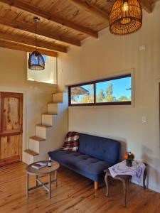 a living room with a blue couch and stairs at Casa Coguil - Camino Topocalma in Los Quillayes