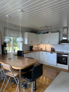 a large kitchen with a wooden table and chairs at Stuga nära sjö och skog in Bengtsfors