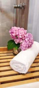 eine Vase mit rosa Blumen auf einem Tisch in der Unterkunft Szczyrkowska Ostoja in Szczyrk