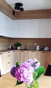 eine Vase voller lila Blumen auf einem Tisch in der Unterkunft Szczyrkowska Ostoja in Szczyrk