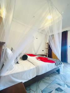 a bedroom with a bed with white mosquito netting at Snuggle Cottage in Ella