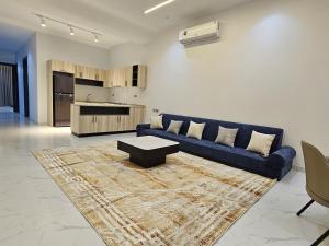 a living room with a blue couch and a table at Ubar-Salalah in Salalah