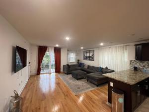 una sala de estar con un sofá y una mesa en Blissfully Large 3 bedroom 3 king beds newark airport, en Newark