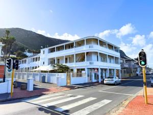 a white building with a car parked in the street at Dalebrook Place Kalk Bay near Tidal Pool in Kalk Bay +85 photos