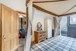 Un dormitorio con cama con dosel y una sala de estar. en Fell View - Bellman House, en Crook