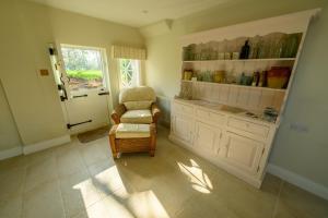 a large kitchen with a chair and a window at The Georgian Coach House:New Forest with hot tub in Fordingbridge +44 photos