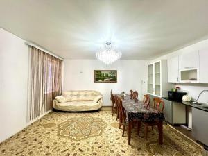 a kitchen and dining room with a table and a couch at Tims house in Karakol
