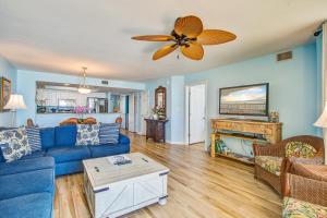 a living room with a blue couch and a ceiling fan at Charleston Oceanfront Villas 112 in Folly Beach