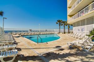 a swimming pool with lounge chairs and the beach at Charleston Oceanfront Villas 311 in Folly Beach
