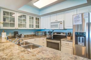 een keuken met witte kasten en roestvrijstalen apparaten bij Charleston Oceanfront Villas 112 in Folly Beach +17 foto's