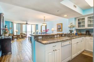 a kitchen with a sink and a living room at Charleston Oceanfront Villas 112 in Folly Beach