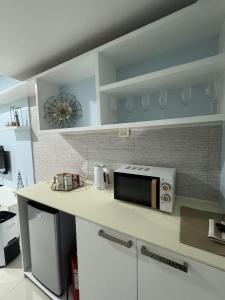 une cuisine avec un comptoir avec un micro-ondes dessus dans l'établissement SMDC wind residences, à Kaybagal 4 autres photos