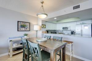 a kitchen and dining room with a wooden table and chairs at Charleston Oceanfront Villas 420 in Folly Beach