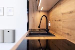 a kitchen with a black sink on a wooden counter at Family and Friends Apartments Bled in Spodnje Gorje +37 photos