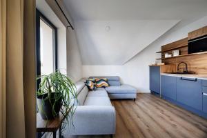 a living room with a couch and a kitchen at Family and Friends Apartments Bled in Spodnje Gorje