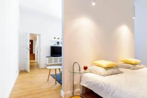 a bedroom with a bed and a table and a kitchen at Apartament Centrum in Poznań