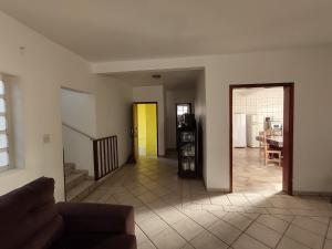 a living room with a couch and a dining room at Casa Amarela in Goiás